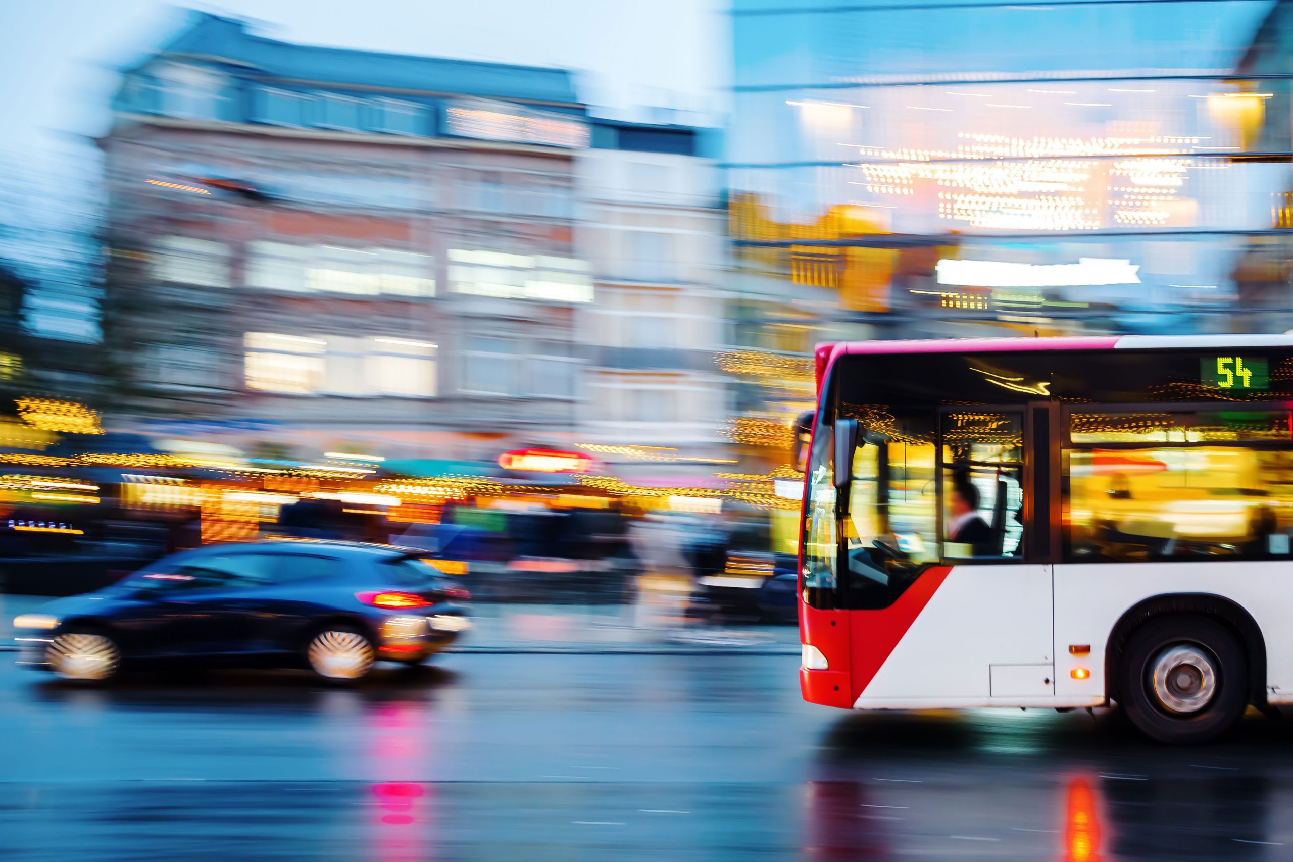 Blurry car and bus driving in the city in the evening