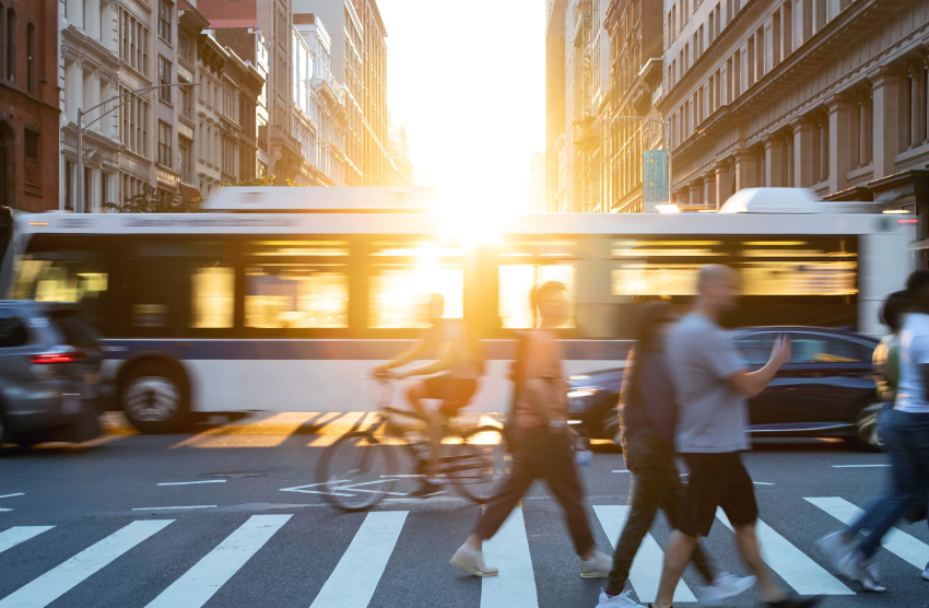 busy urban intersection with cars, city bus, bicycle and pedestrian traffic