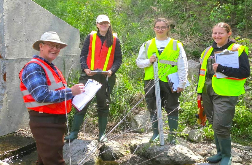 Four people in brightly colored vests