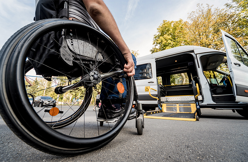 Person in wheelchair rolling heading toward a paratransit van