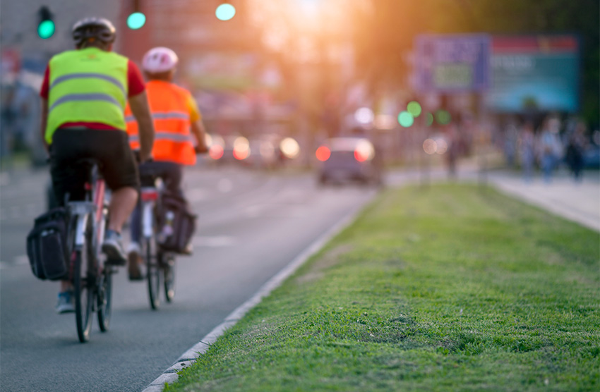 people riding bicycles on street with cars